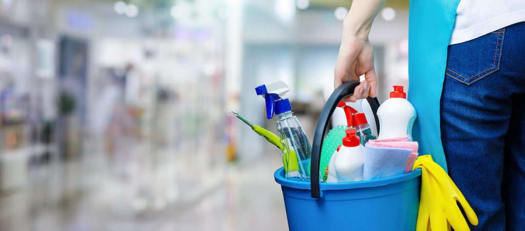 Commercial cleaner carrying cleaning products in a workplace
