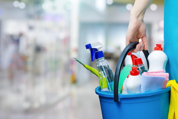 Commercial cleaner carrying cleaning products in a workplace